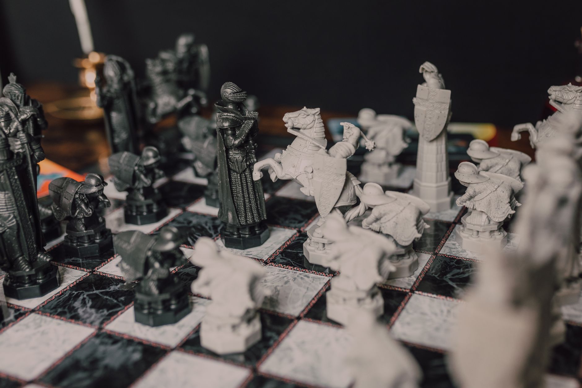 Close-up of ornate chess pieces on a classic marble chessboard, evoking a magical theme.