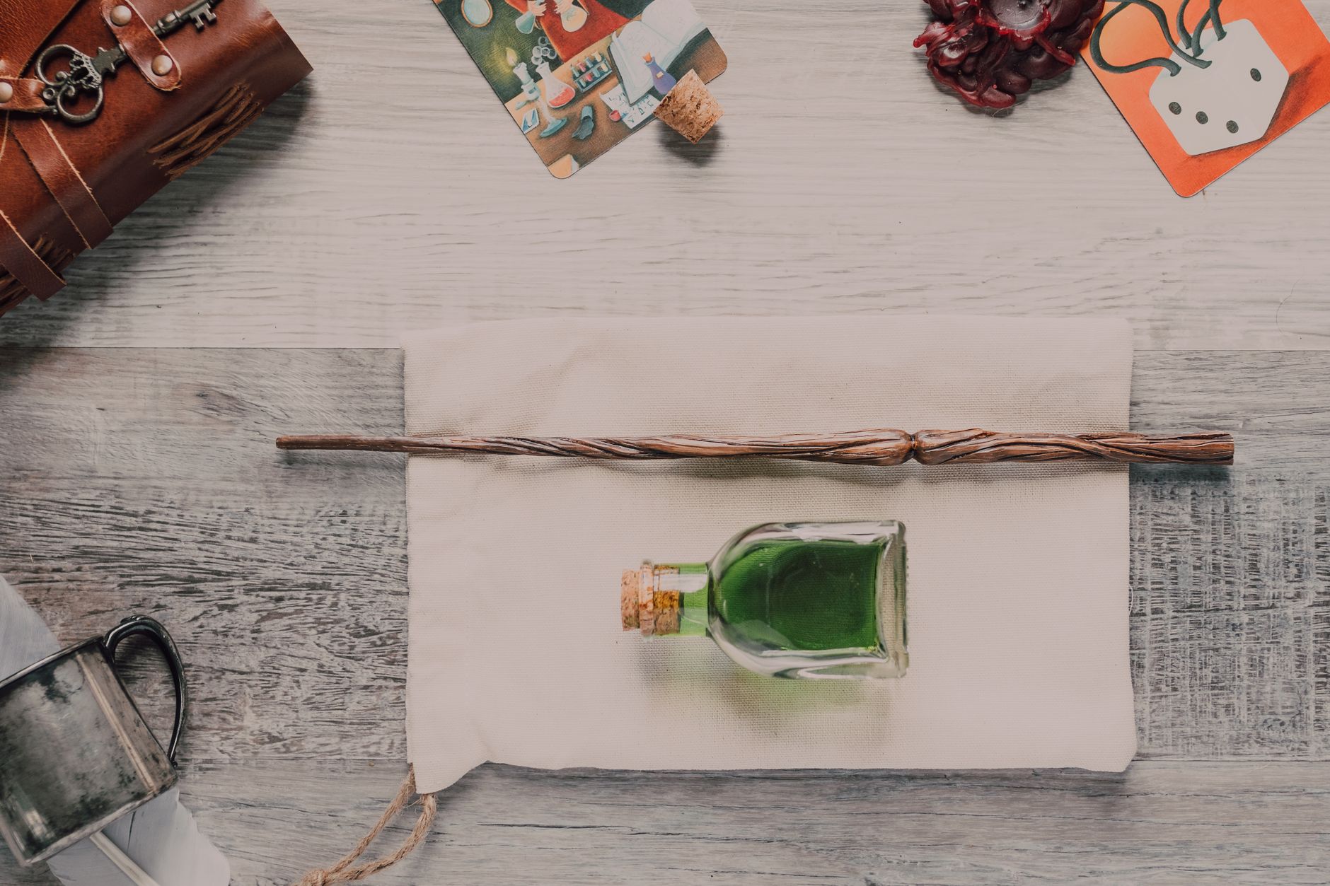 Enchanting flatlay featuring a wand and green potion bottle on rustic wood.