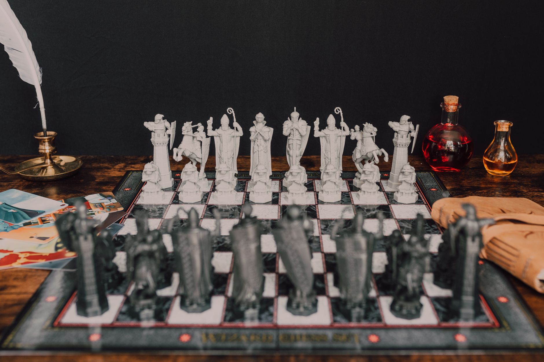 A vintage wizard-themed chess set with fantasy figurine pieces on a rustic table.