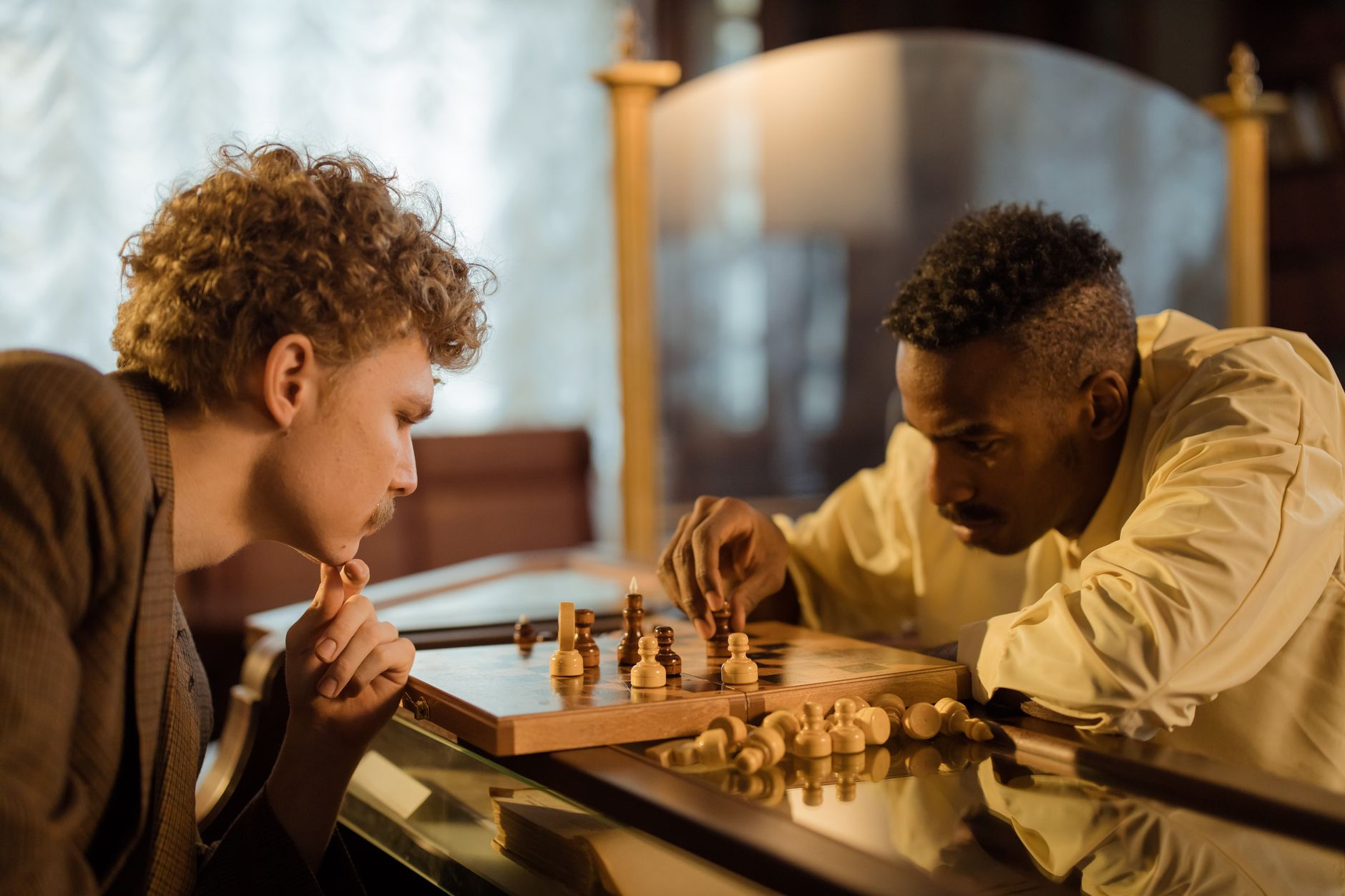 Two men focused on a chess game indoors, embodying strategy and concentration.