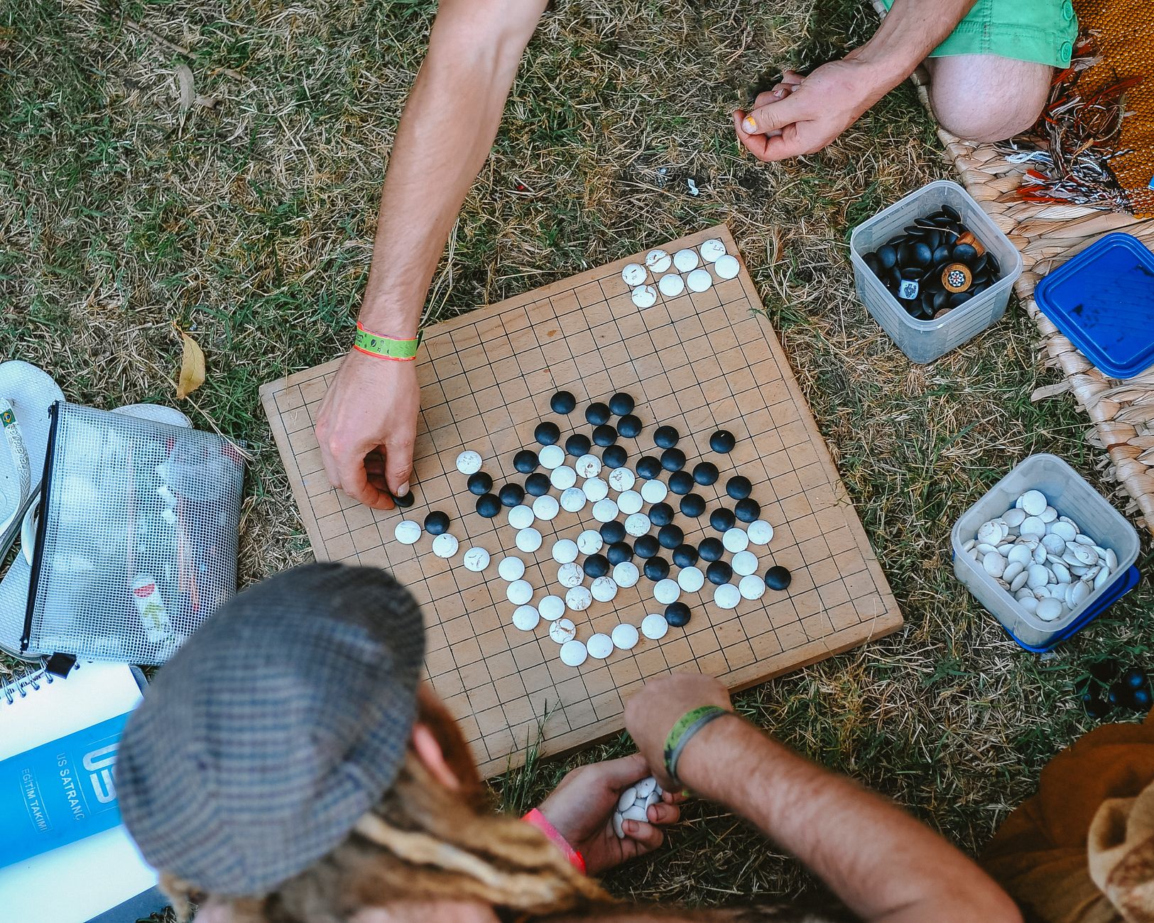 Aerial view of people playing Go outdoors, showcasing a casual game setup on a grassy lawn.