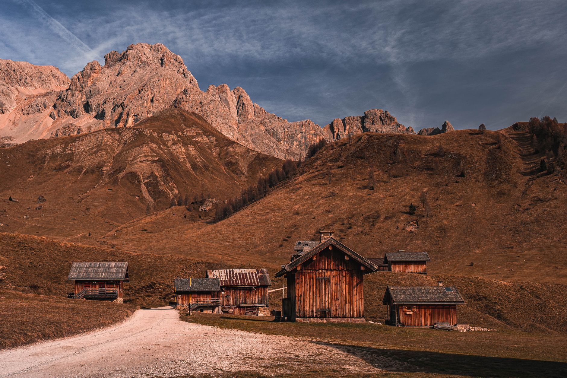Charming wooden cottages in a serene alpine landscape with imposing mountain views.