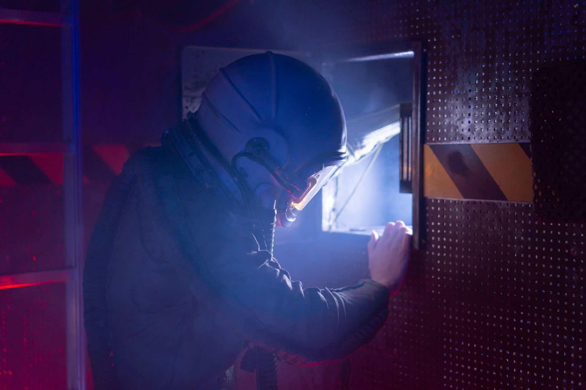 A woman astronaut in a space suit exploring a futuristic spacecraft interior with atmospheric lighting.