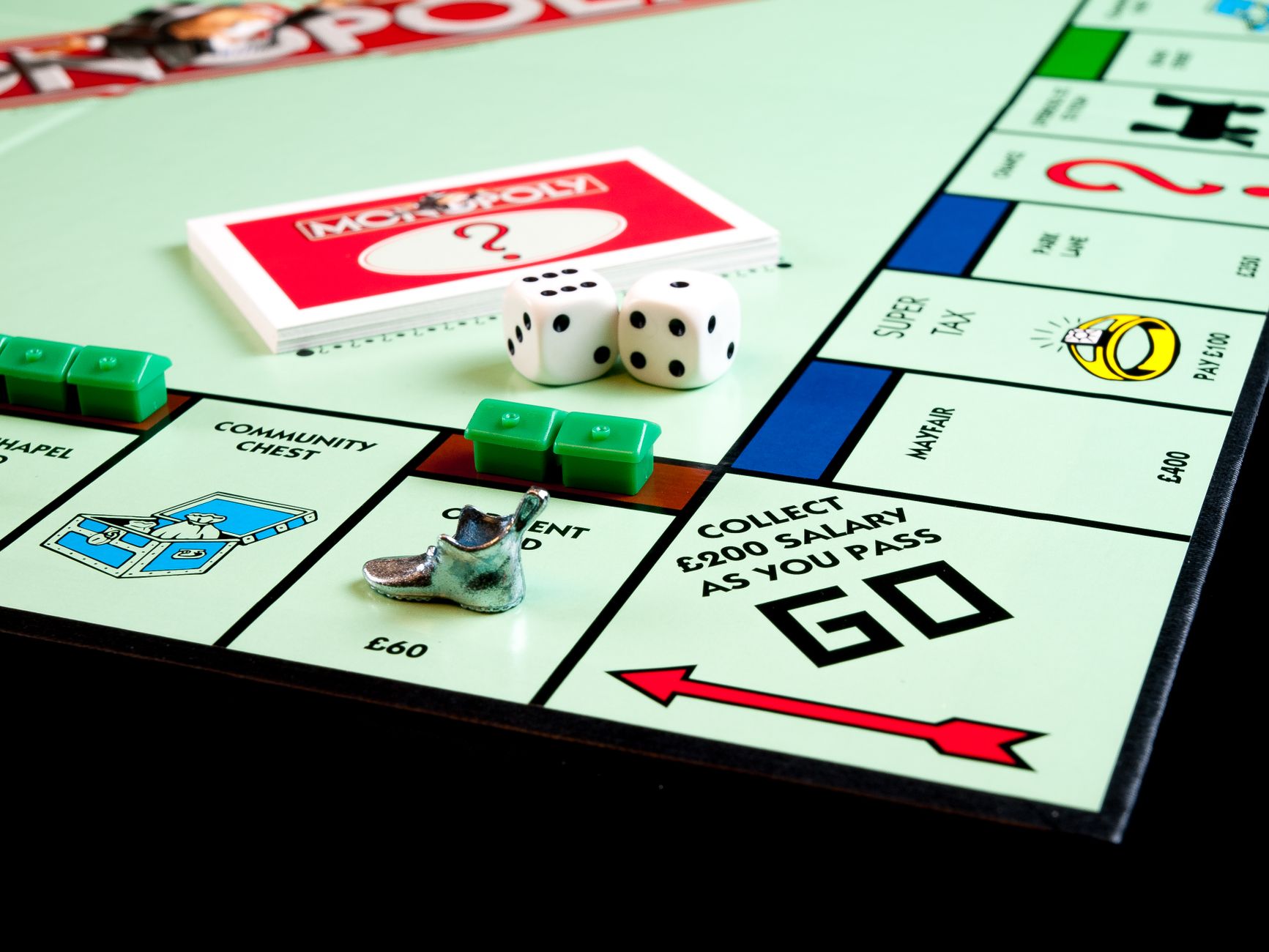Detailed view of Monopoly board game pieces, dice, and properties.