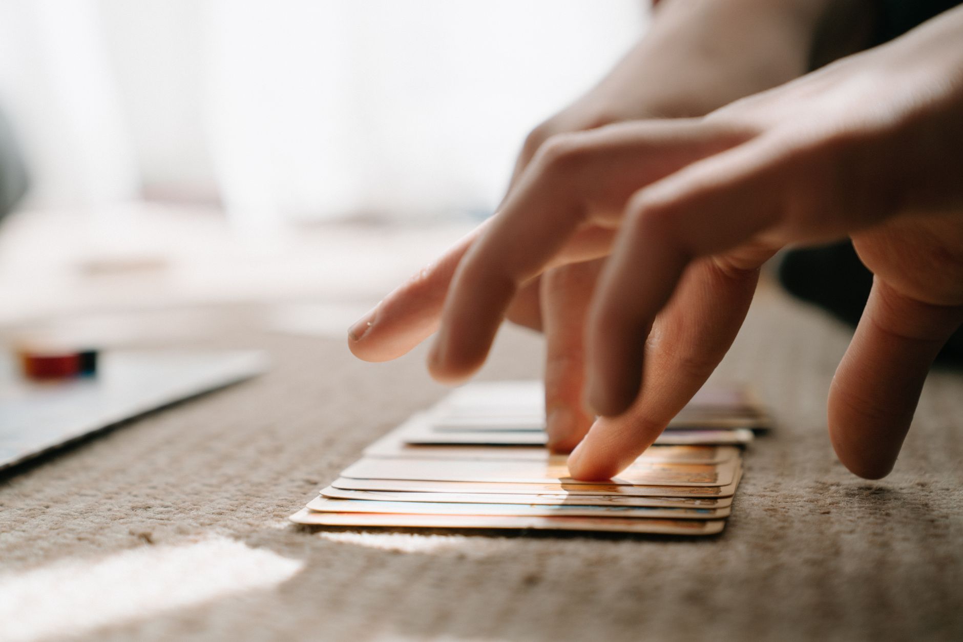 Intimate close-up of hands interacting with cards during a strategic game indoors.