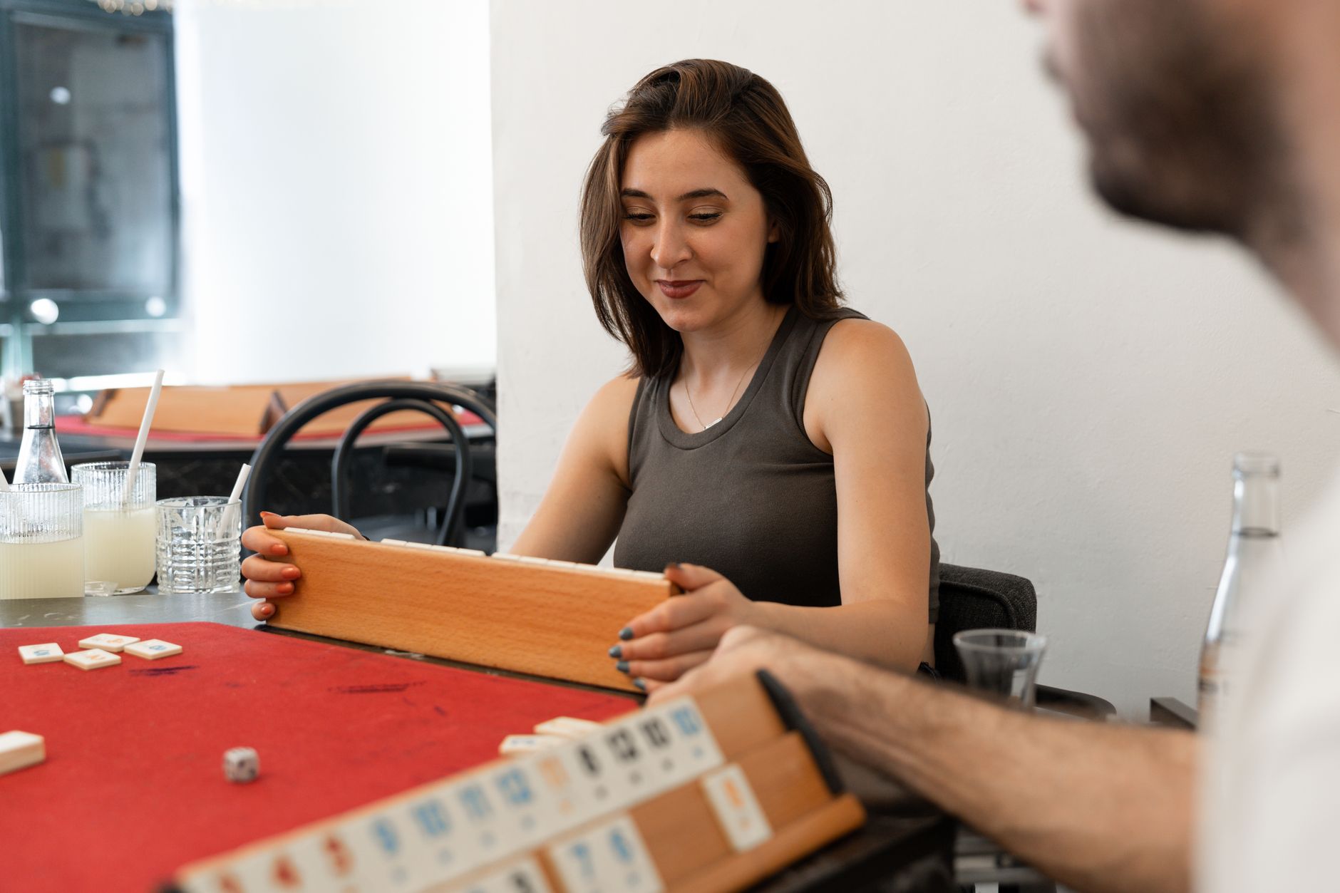 A woman engaging in a board game with friends in a casual indoor setting, creating a relaxed atmosphere.