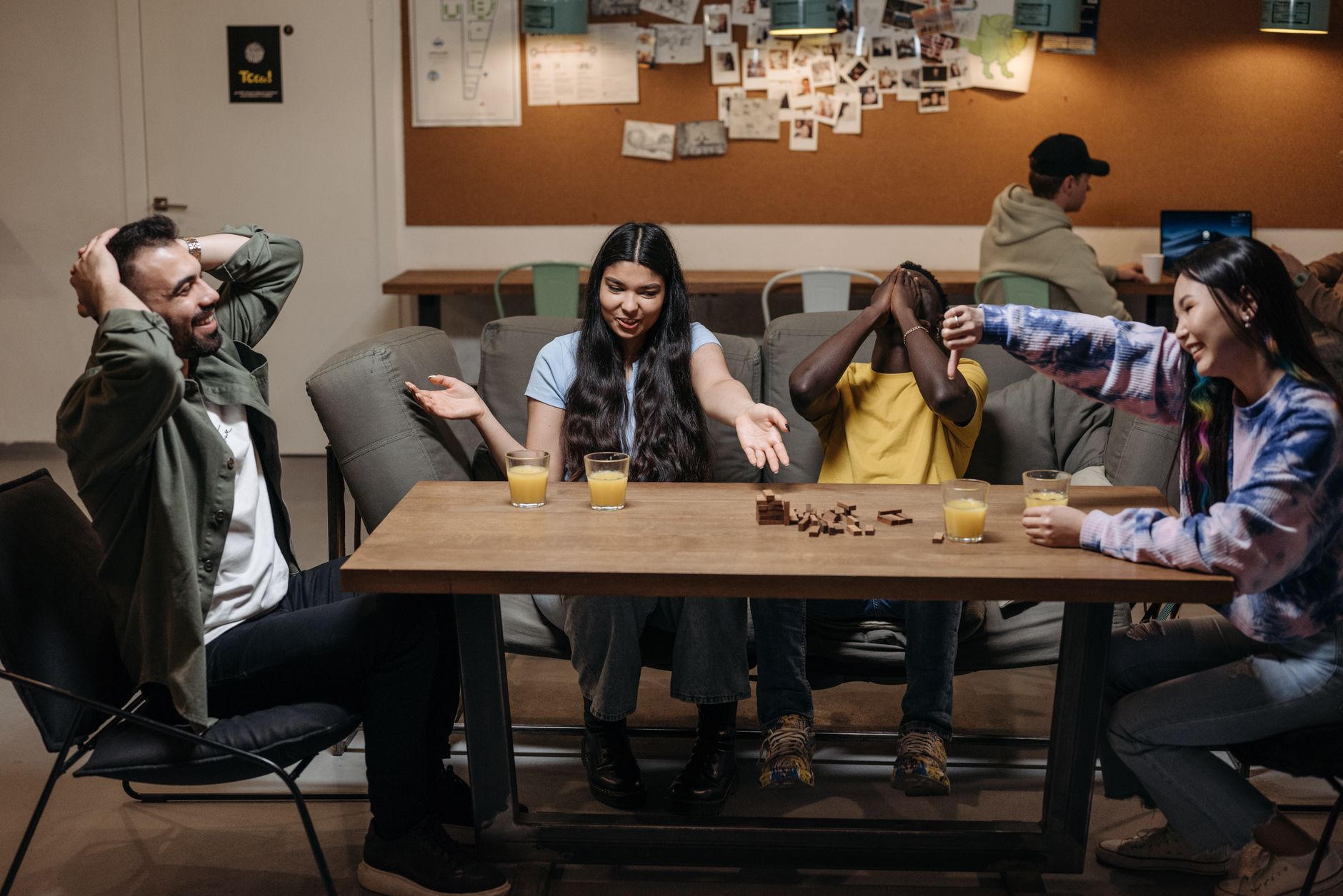 Friends socializing over board games and drinks in a cozy indoor setting.