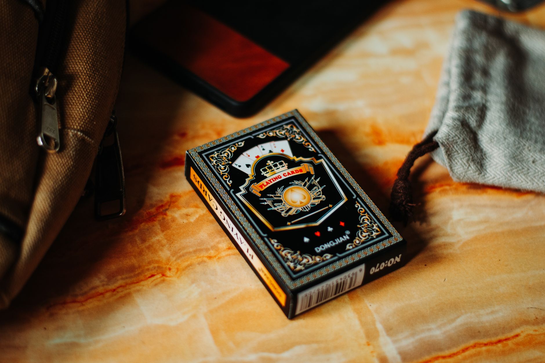 Close-up of a box of intricate playing cards elegantly displayed on a marble surface.