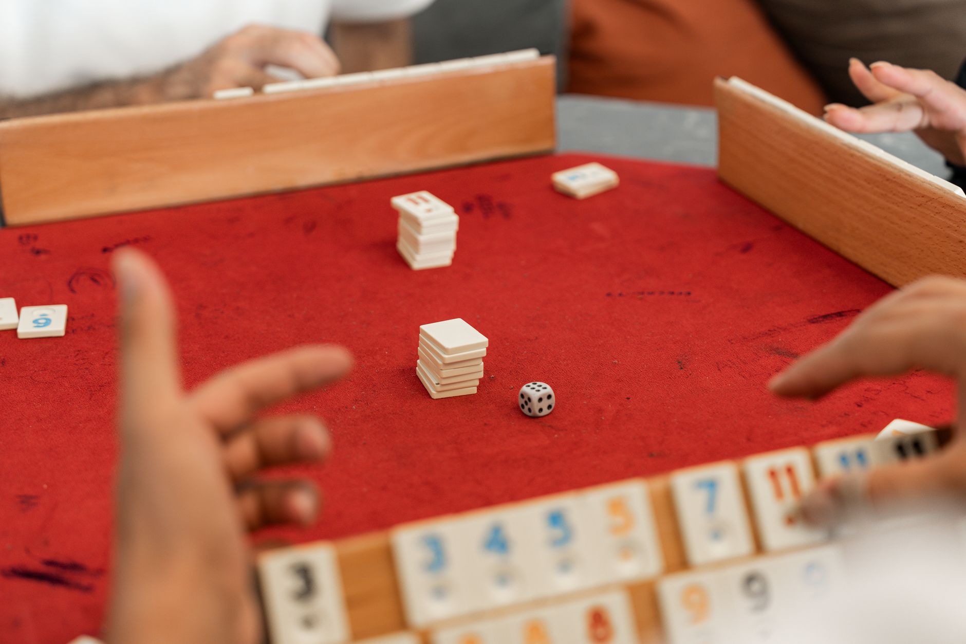 A lively indoor scene of adults playing Rummikub, highlighting leisure and skillful gameplay.