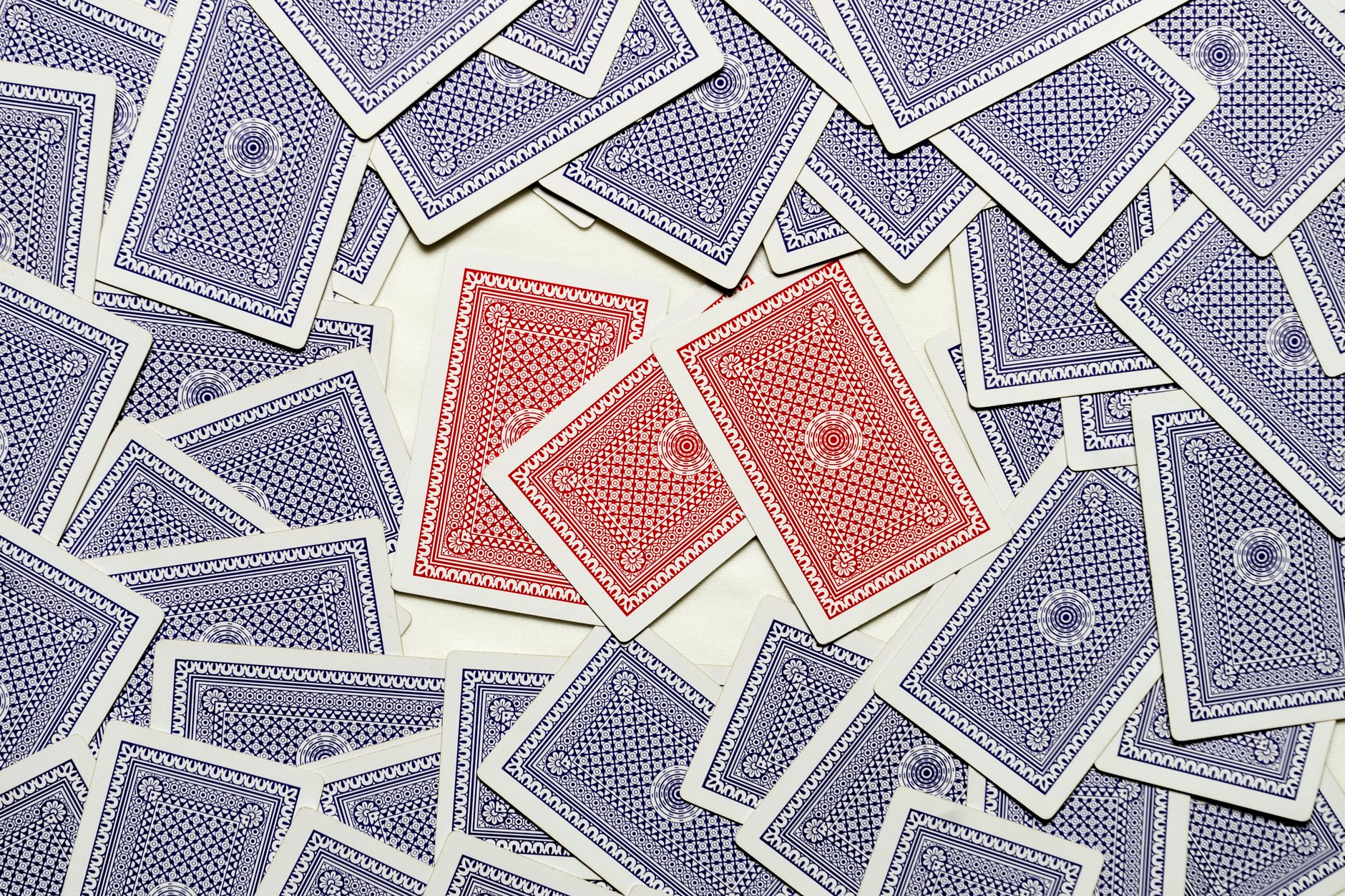 A detailed flat lay of red and blue playing cards scattered on a surface.