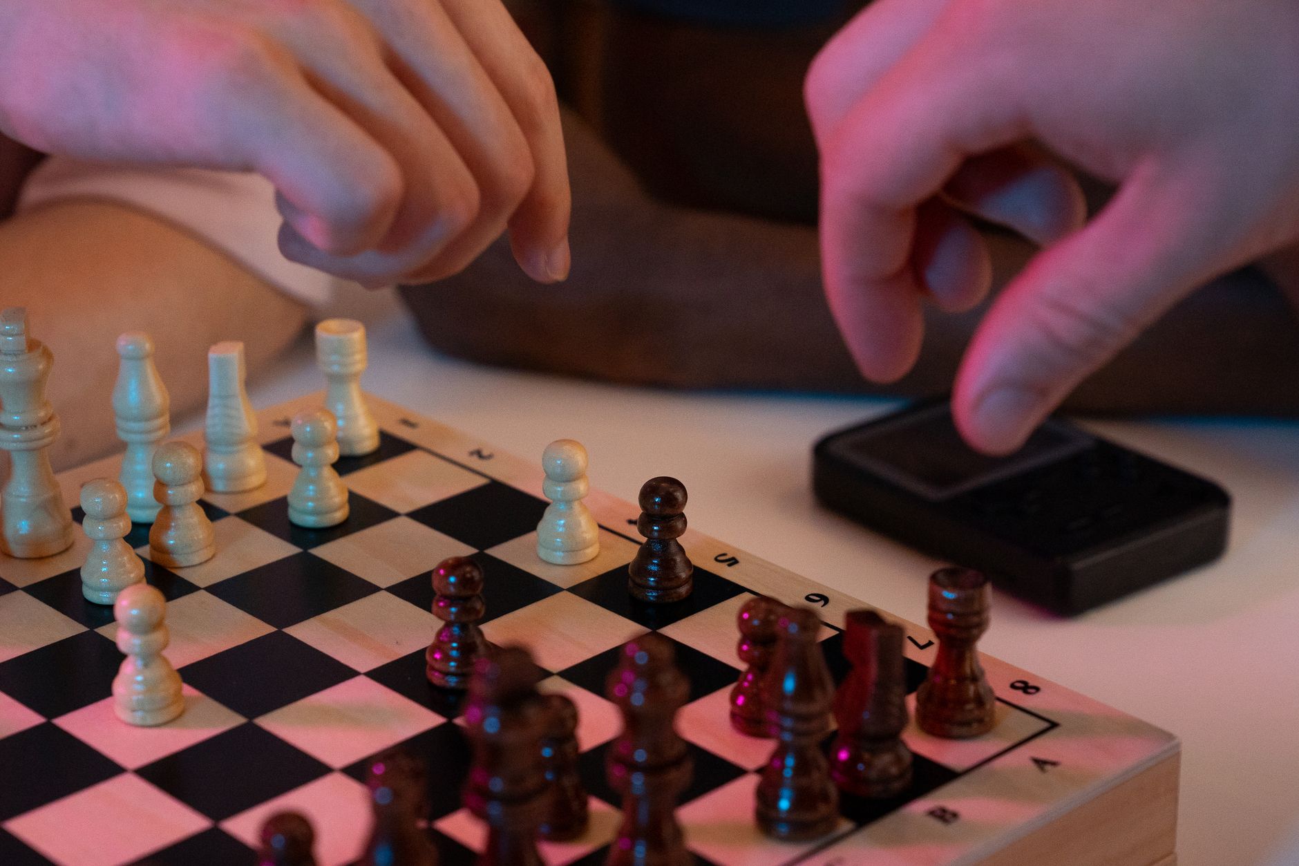 Close-up of hands playing a chess game, capturing strategic moves and intense focus.