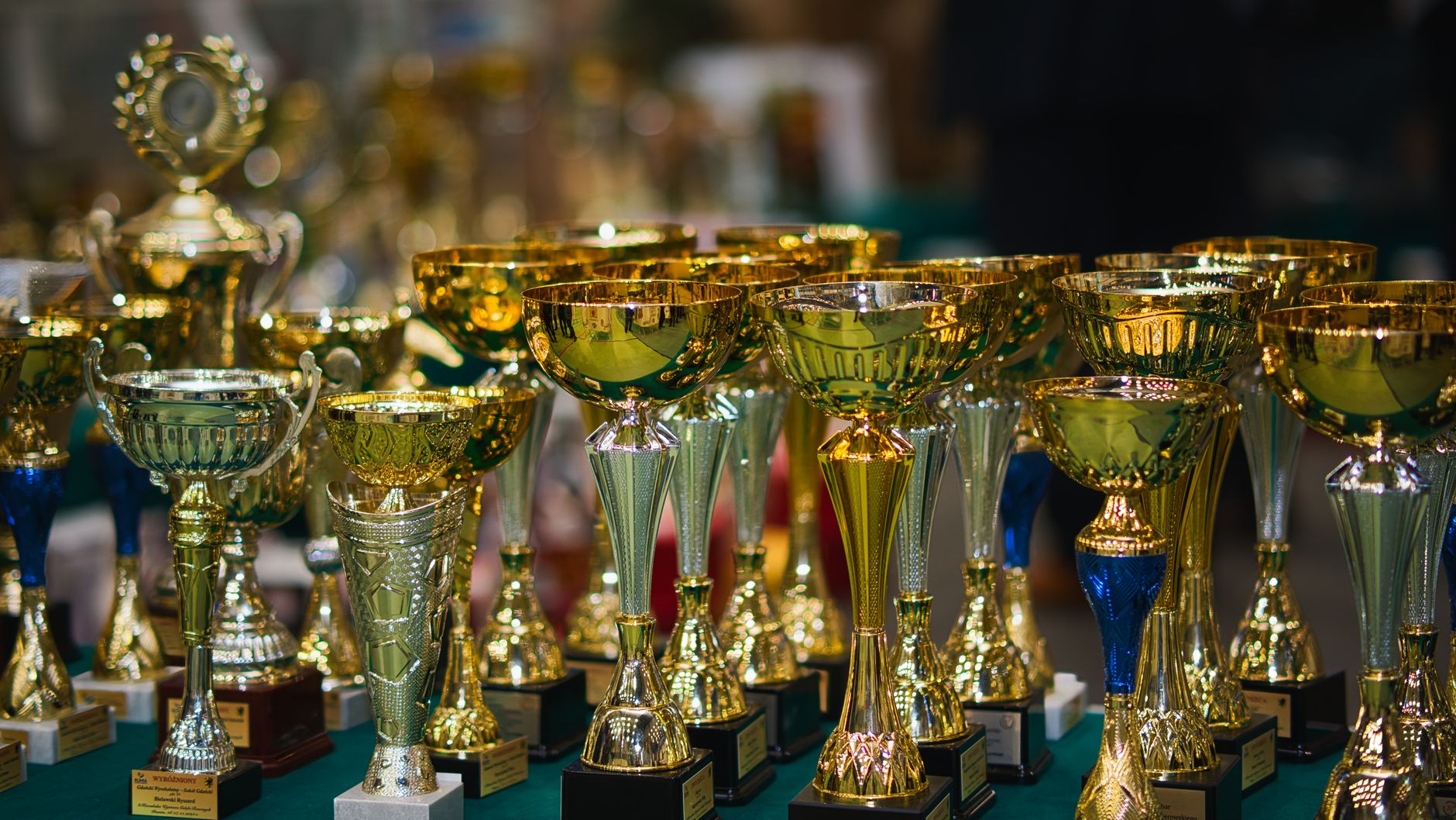 Array of golden trophies on a table, reflecting victory and achievement.