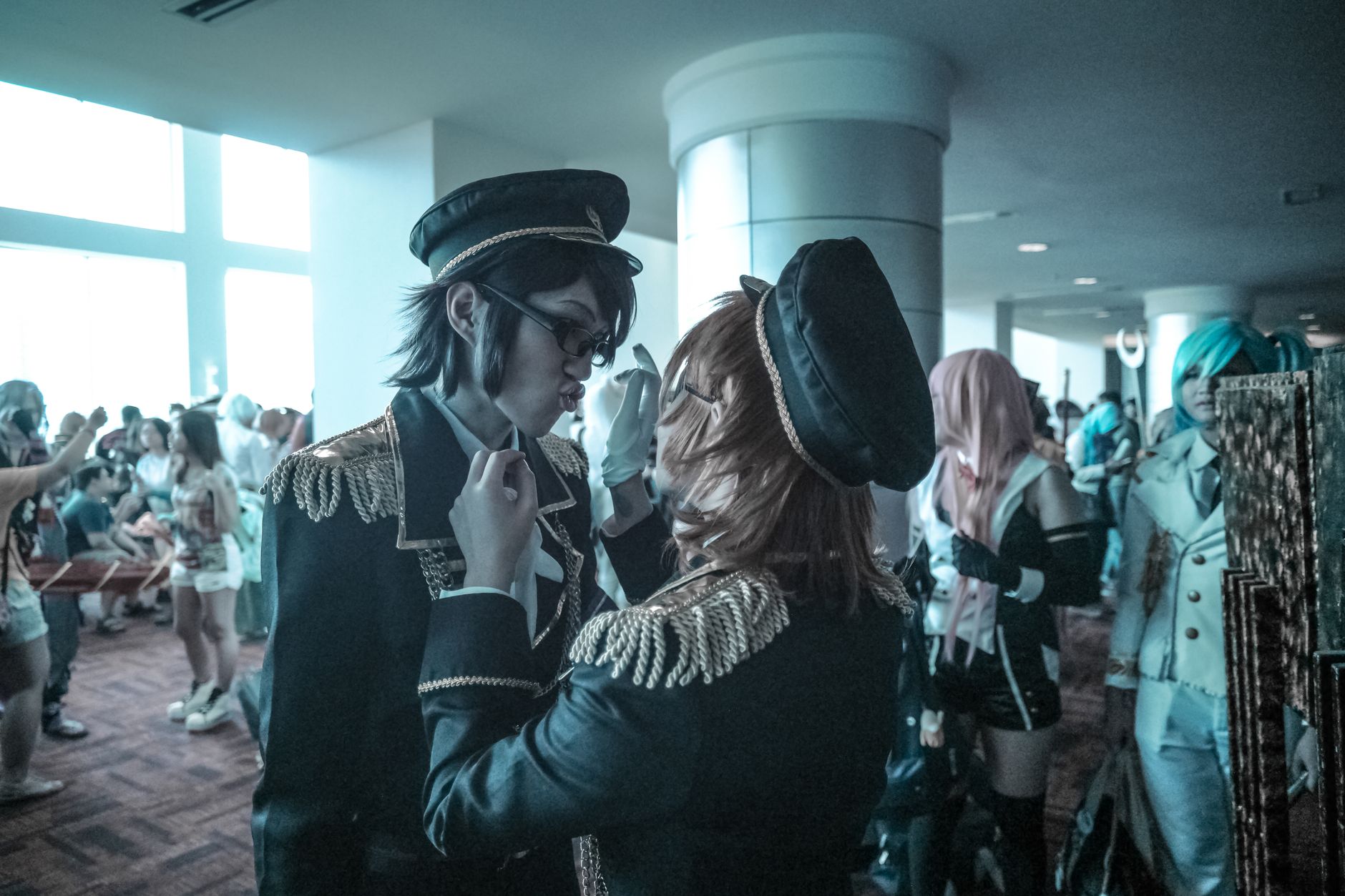 Cosplayers engage at a vibrant indoor anime festival with diverse costumes and glowing community spirit.