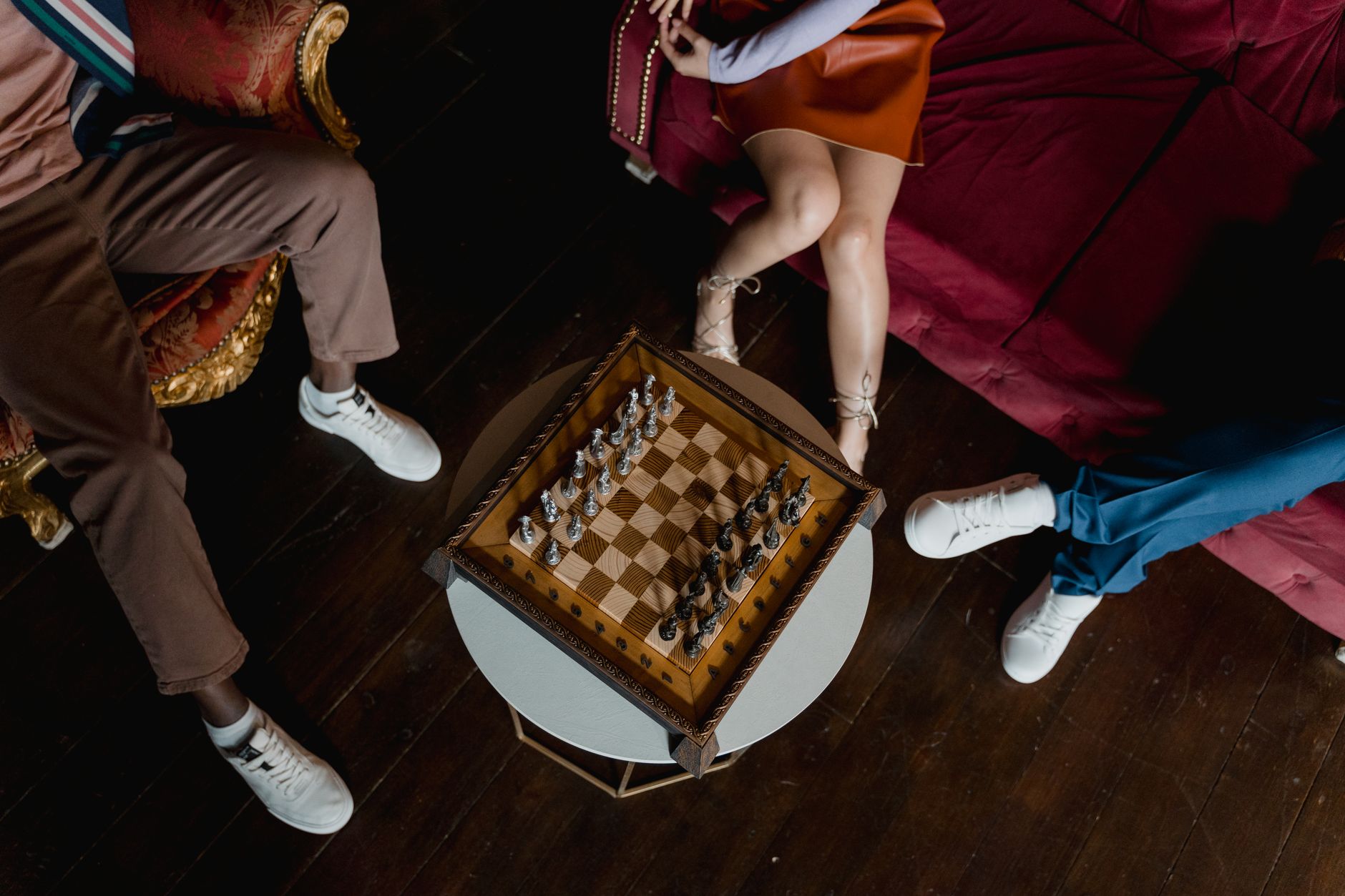 Overhead view of chess game setup with players seated, creating a warm, strategic atmosphere.