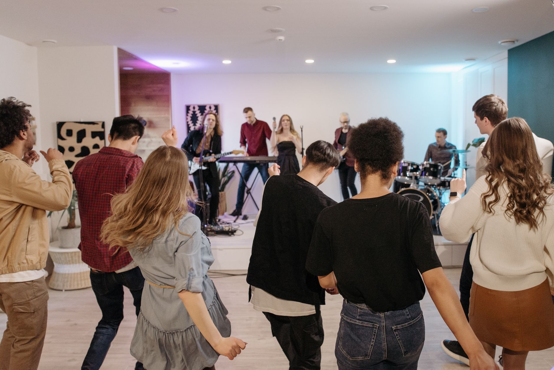 A vibrant indoor concert with an energetic crowd dancing to live music.