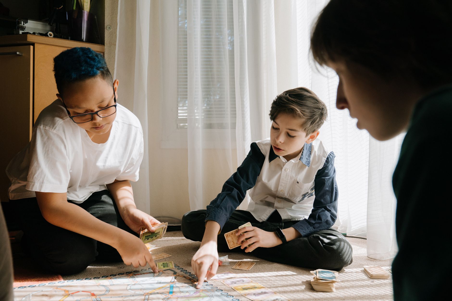 A group of kids engaged in a strategy board game in a cozy indoor setting.