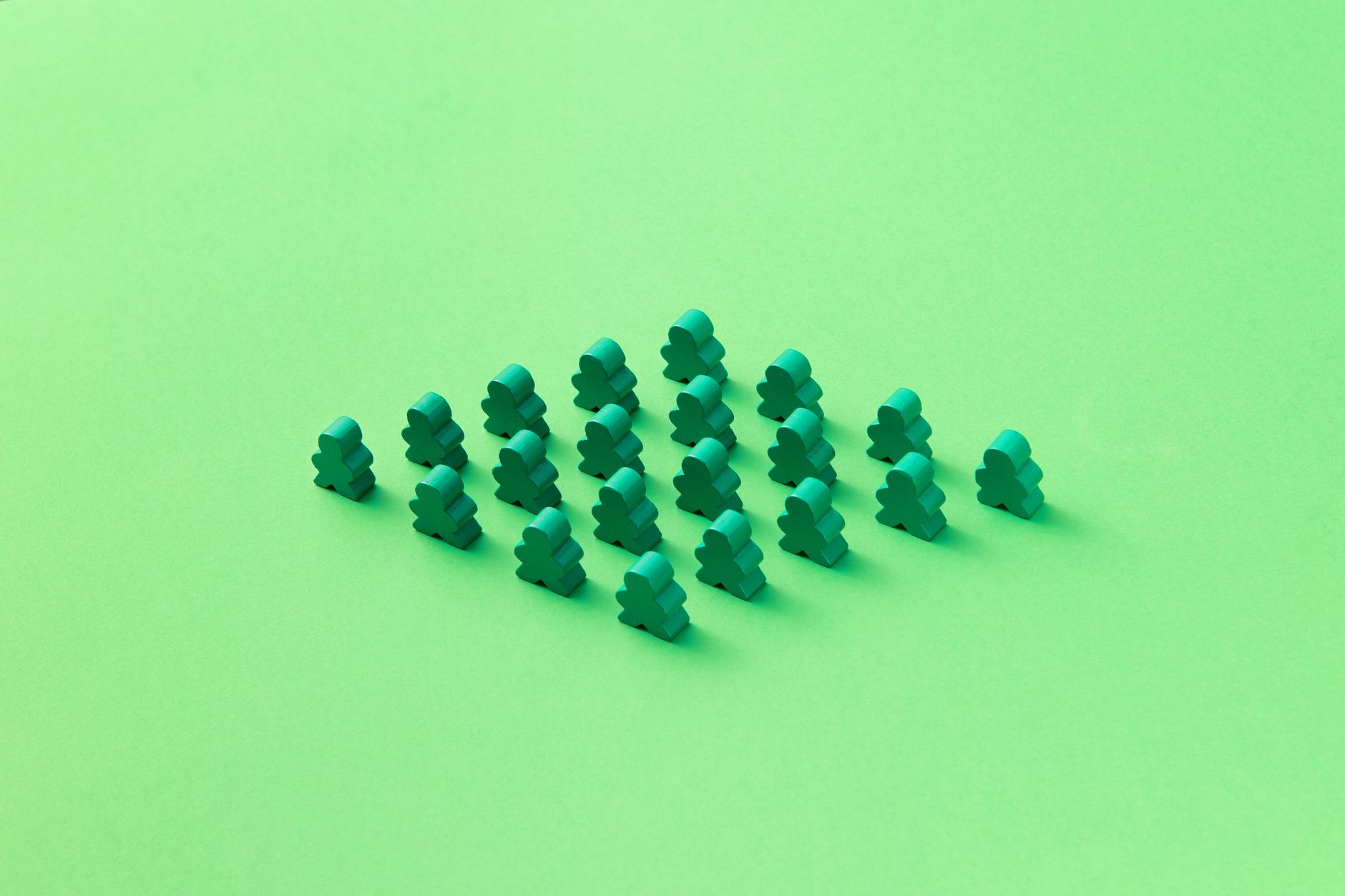 Green meeples arranged in a triangular pattern on a vivid green background. Perfect for board game themes.