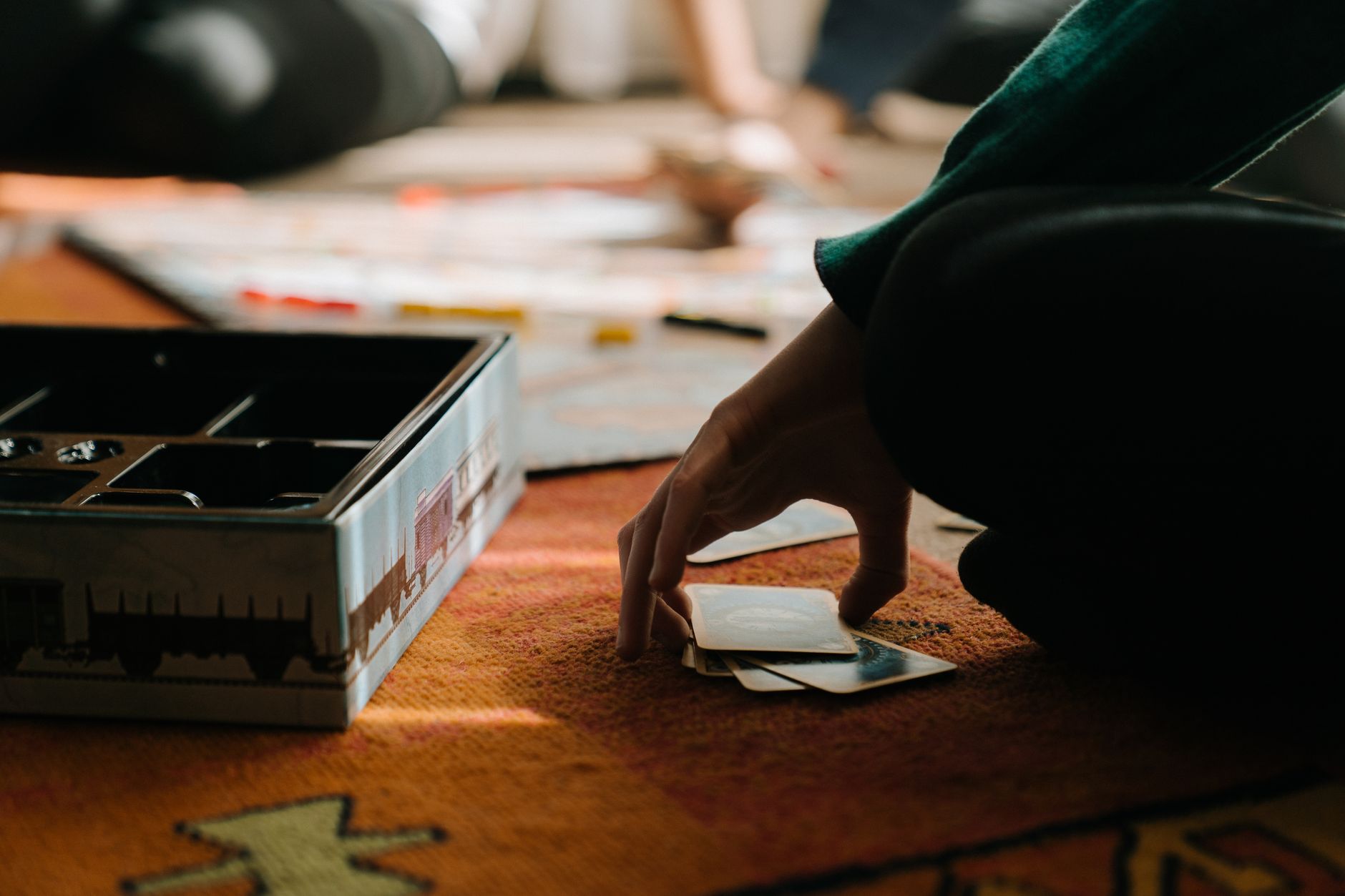 Close-up of hands playing a board game, capturing the strategy and thought involved.
