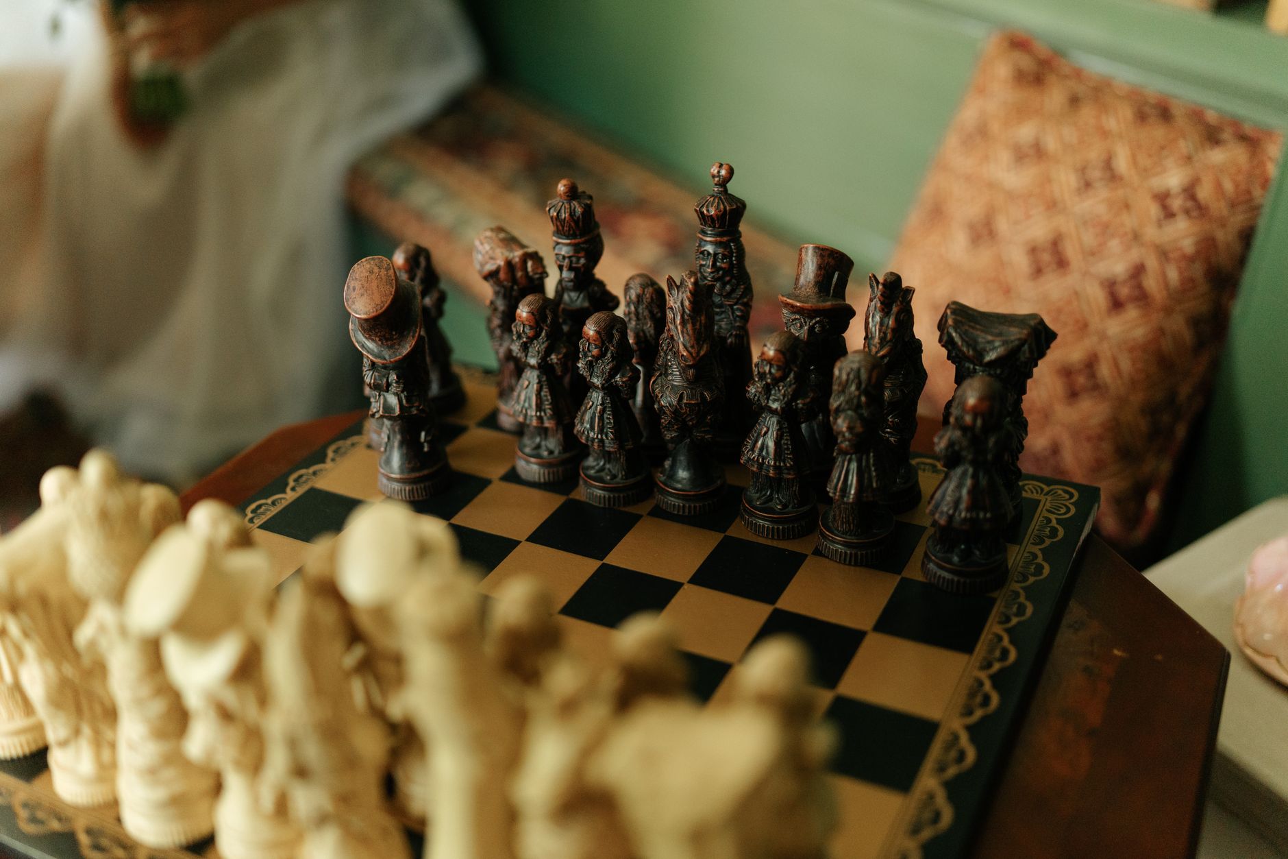 A detailed view of a vintage-style chess set with intricately sculpted pieces in a warm, cozy living room.